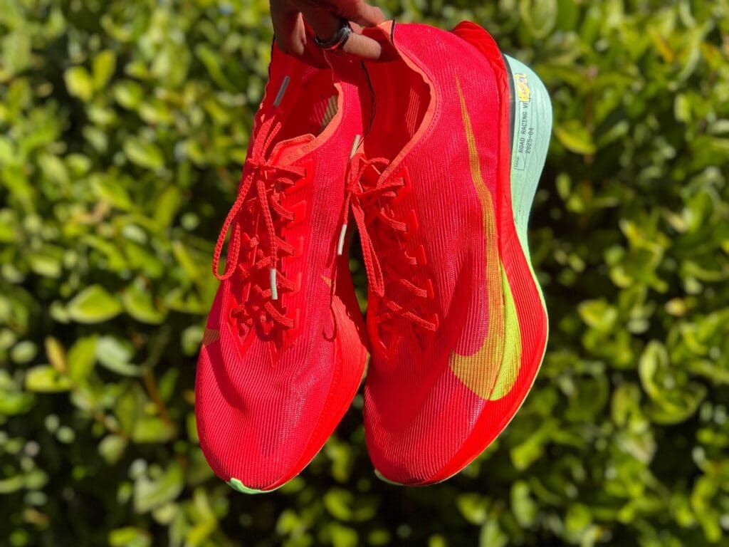 hands holding red nike vaporfly 4 shoes outside