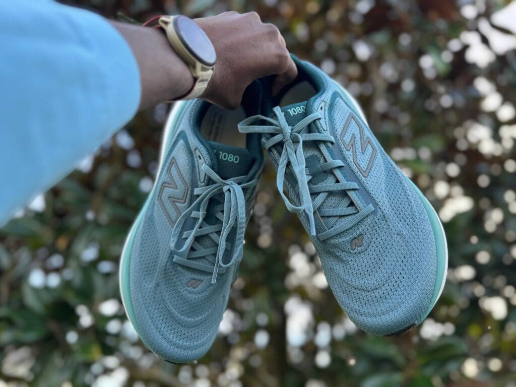 Pair of new balance 1080 v15s in hand
