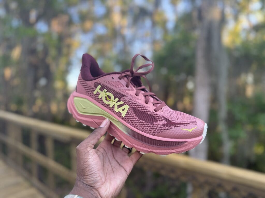 hoka challenger 8 in hand with trail in background
