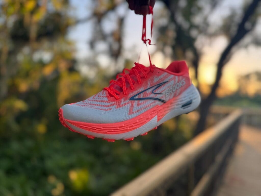 Brooks Catamount 4 hanging by shoe lases with sunset in the background on trail