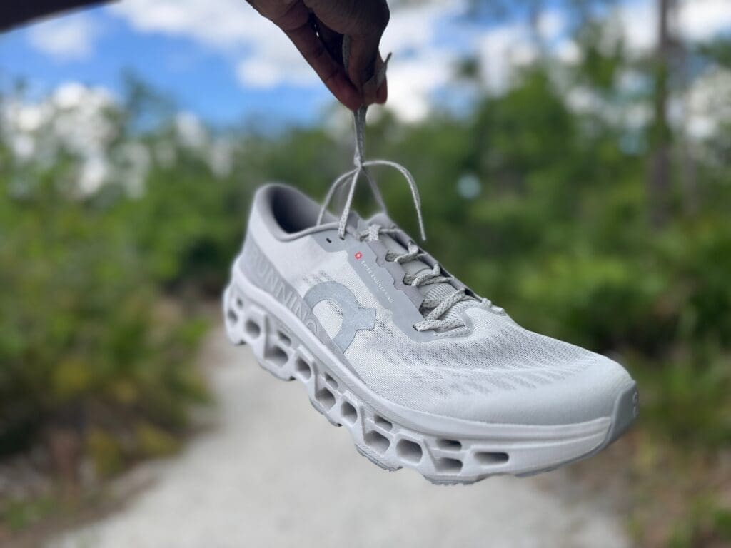 On Cloudmonster 3  dangling by laces on running path