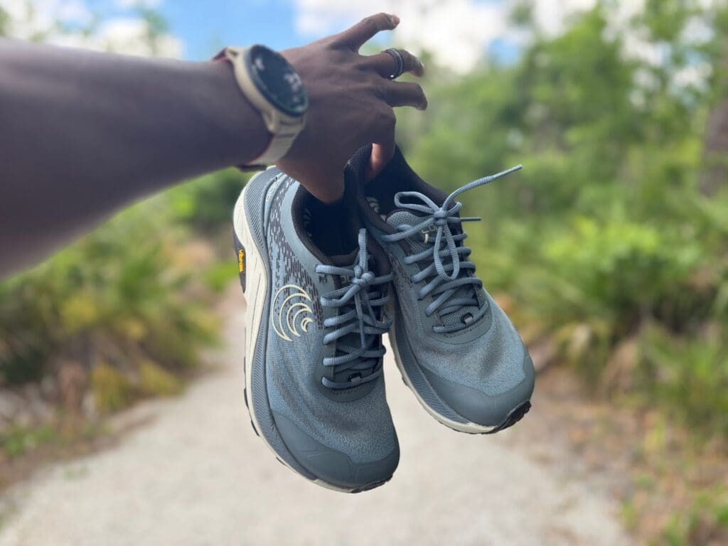 Topo Ultraventure 4 in hand with gravel trail in background