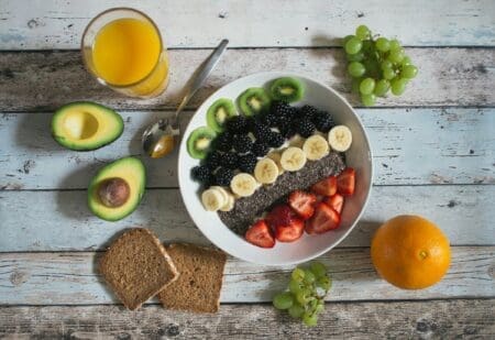 Why All-or-Nothing Thinking Ruins Most Health Goals (And What to Do Instead) fruit on a plate with orange juice whole wheat toast an avocado an orange and leafy greens