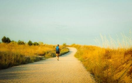 man wearing wide footed shoes running on path