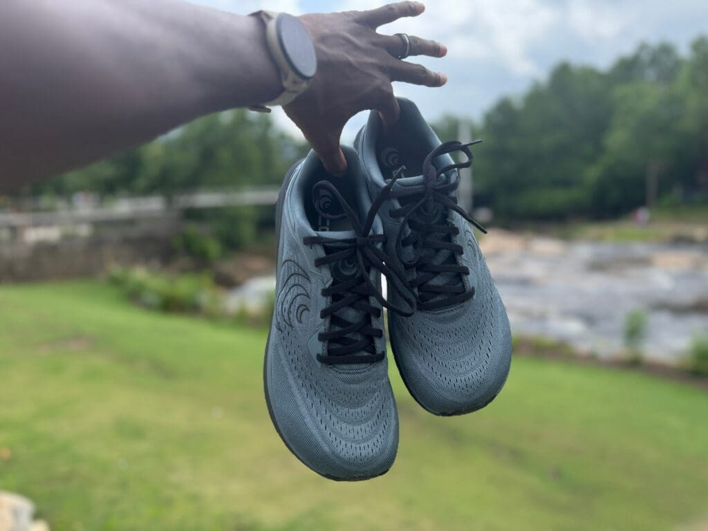 Topo Athletic Phantom 4 in hand with river and park in background