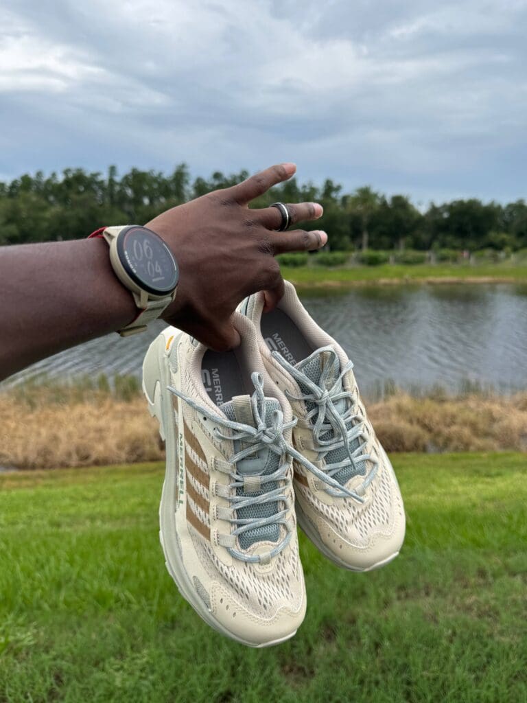 person holding Merrell Moab Speed 2 with pond in background