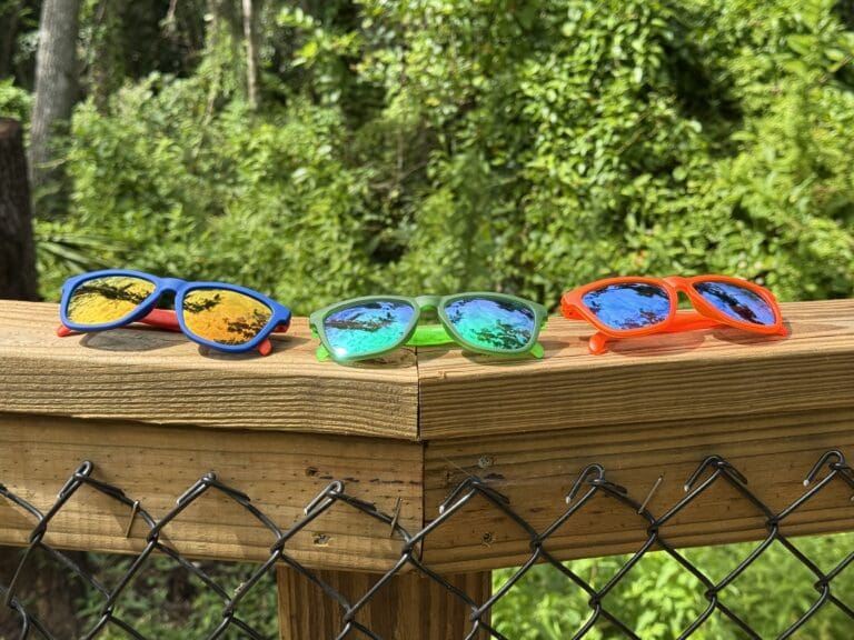 3 goodr sunglasses side by side product shot on trail bridge