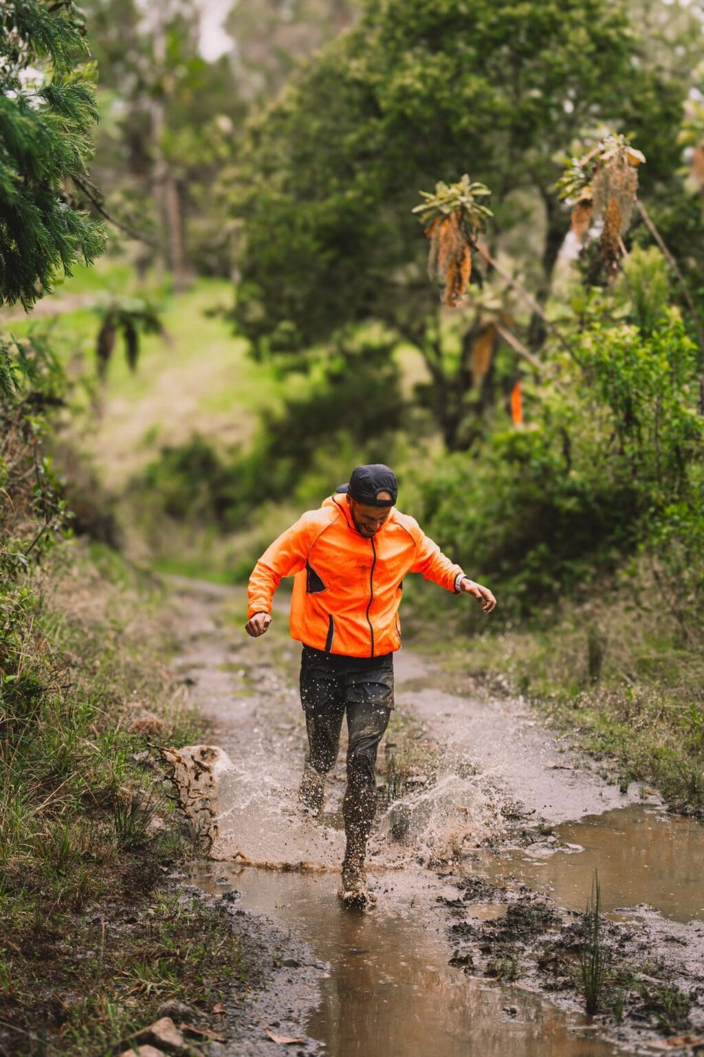 How to Run in the Rain: Keep Feet Dry, Warm, & Blister-Free man running through a wet puddle in the rain