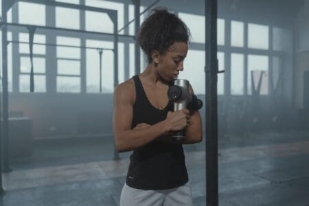 6 Best Massage Guns for Runners of 2026: Deep Tissue Recovery girl using massage gun in gym
