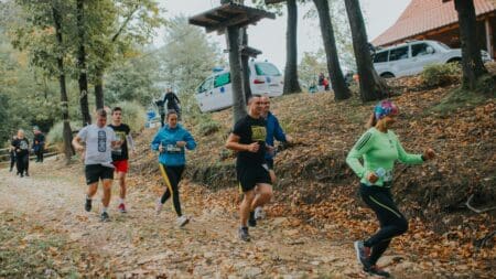 36 Halloween-Themed 5Ks, Races, Runs & Walks in West Central Florida: October 2026 Calendar Group of trail runners running downhill through golden autumn fallen leaves in a forest